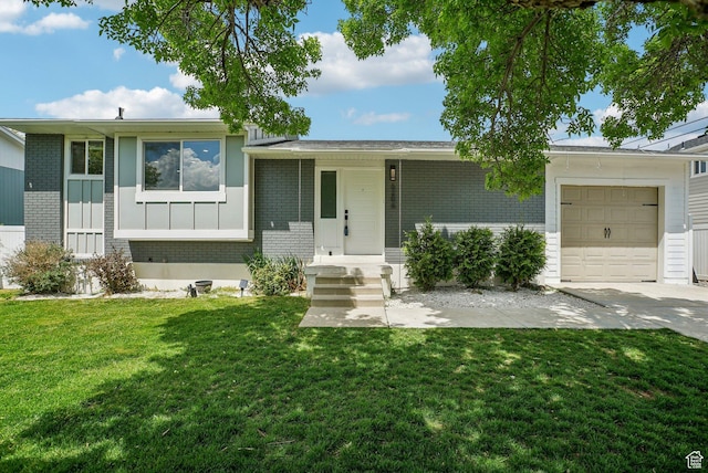 split level home featuring board and batten siding, brick siding, a front lawn, and a garage