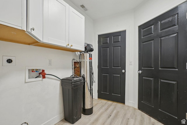 interior space featuring cabinet space, light wood-style flooring, electric dryer hookup, baseboards, and hookup for a washing machine