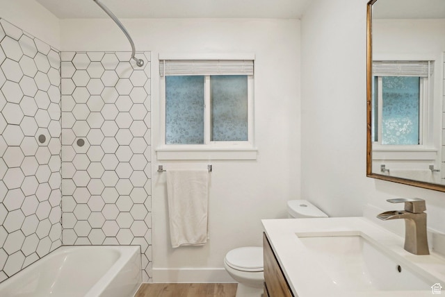 bathroom with toilet, a wealth of natural light, vanity, and bathtub / shower combination