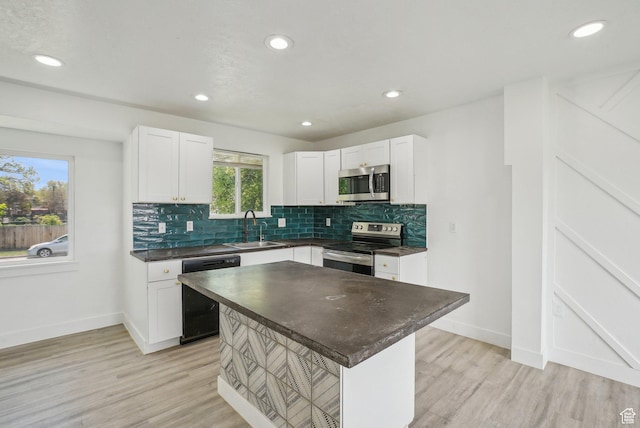 kitchen featuring a sink, decorative backsplash, baseboards, dark countertops, and appliances with stainless steel finishes