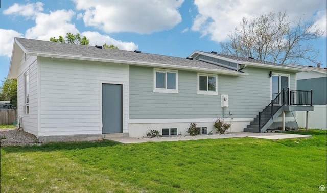 rear view of property featuring a lawn and stairway