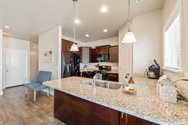 3030 N 125 E, Cedar City, UT 84721 - kitchen with light stone counters, a sink, baseboards, black appliances, and a peninsula