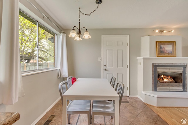 831 S 50 W, Orem, UT 84058 - dining room with visible vents, baseboards, a notable chandelier, and a lit fireplace