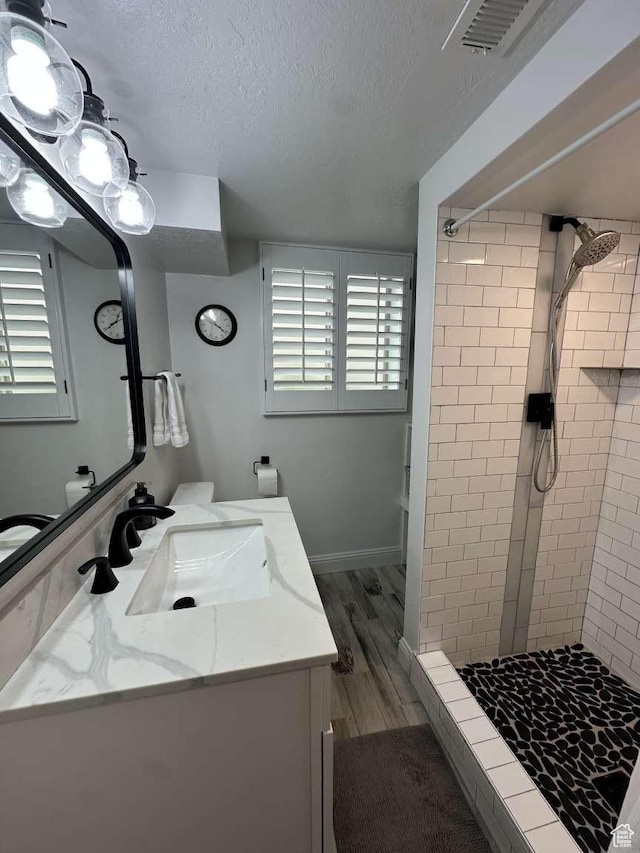 5843 S Fontaine Bleu Cir, Salt Lake City, UT 84121 - full bathroom with a shower stall, wood finished floors, a textured ceiling, vanity, and visible vents