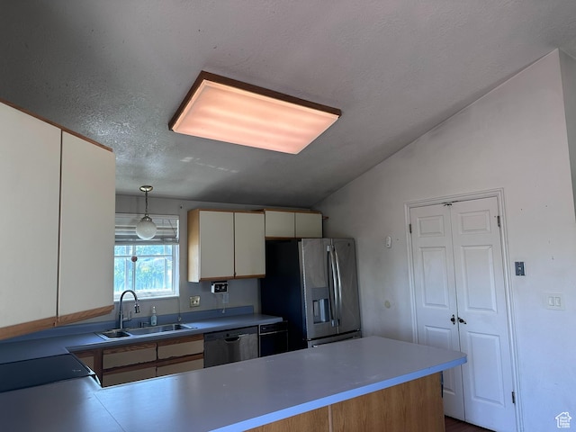 kitchen featuring a sink, pendant lighting, appliances with stainless steel finishes, a peninsula, and lofted ceiling