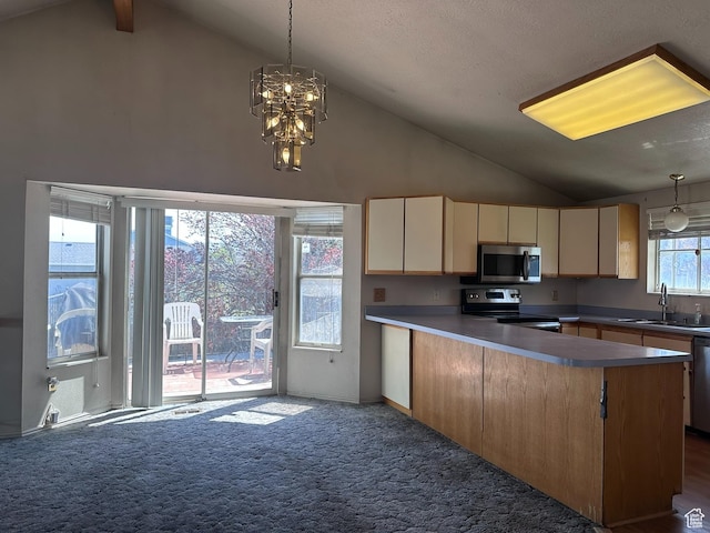 kitchen with dark carpet, a sink, a peninsula, appliances with stainless steel finishes, and high vaulted ceiling