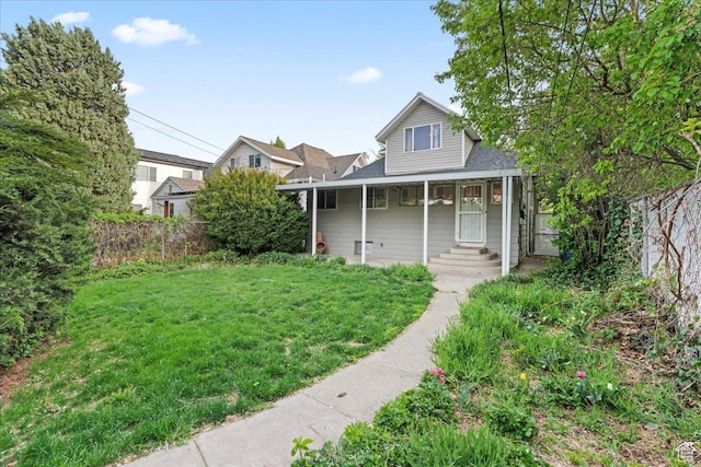 view of front facade with a porch, a front lawn, and fence