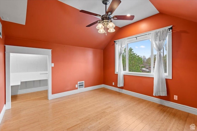 additional living space with wood finished floors, baseboards, visible vents, a ceiling fan, and lofted ceiling