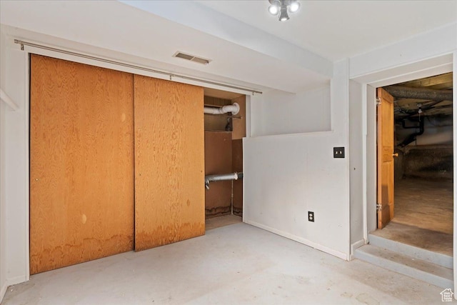unfurnished bedroom with visible vents, unfinished concrete flooring, baseboards, and a closet