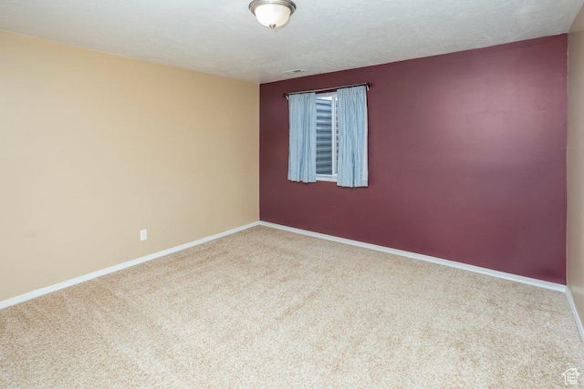 spare room with baseboards and carpet floors