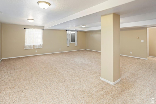below grade area featuring baseboards and carpet