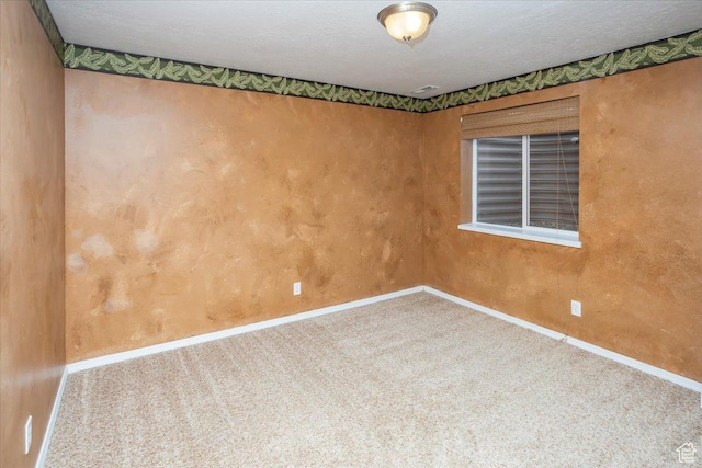 carpeted spare room featuring baseboards