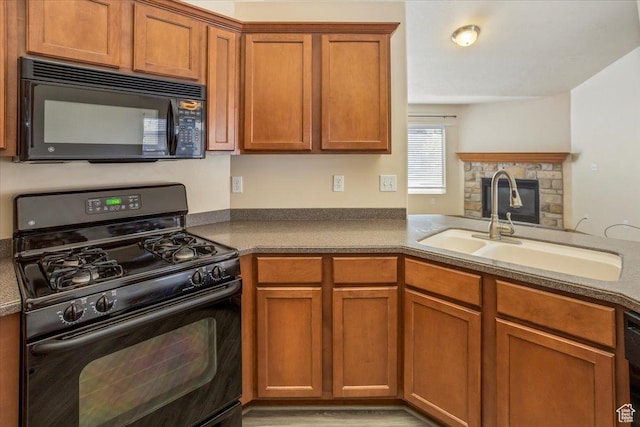 kitchen with brown cabinetry, a sink, and black appliances