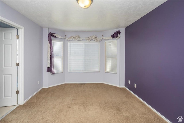 carpeted empty room with baseboards