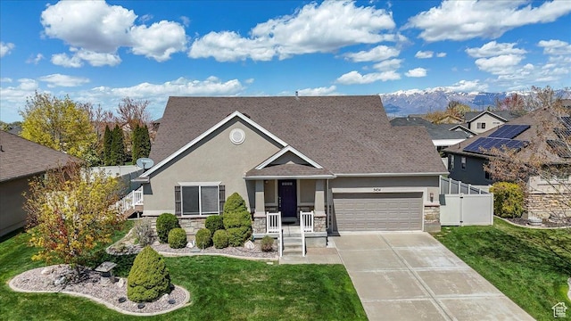 view of front of house with driveway, stone siding, a garage, a front yard, and stucco siding