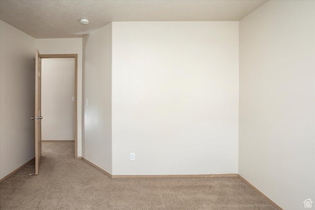 empty room with baseboards and light colored carpet