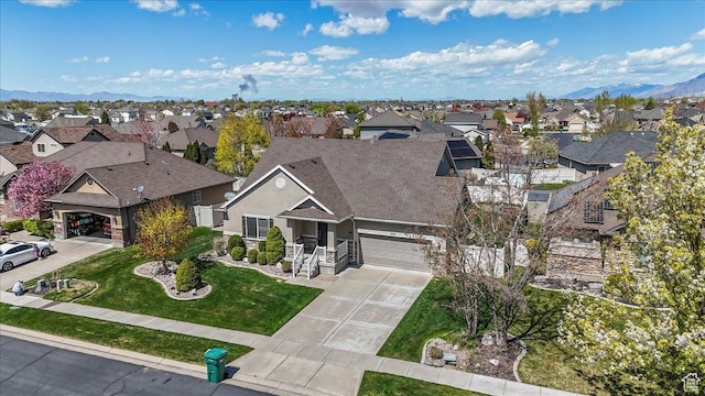 view of front facade with concrete driveway, a front lawn, a residential view, and a garage