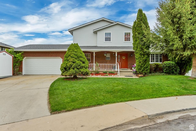 traditional-style house featuring a front lawn, concrete driveway, an attached garage, covered porch, and brick siding