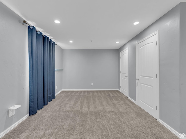 empty room with carpet floors, recessed lighting, and baseboards