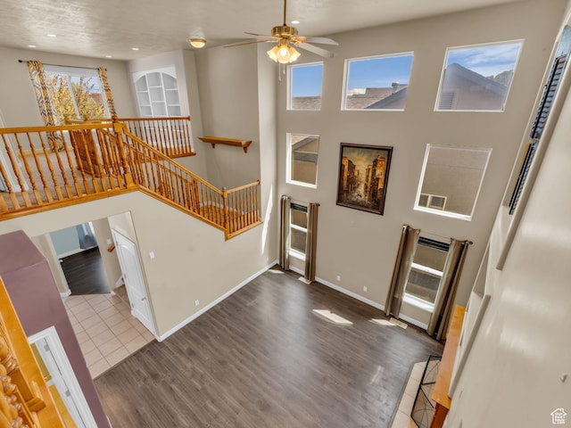 entryway featuring wood finished floors, ceiling fan, baseboards, recessed lighting, and stairway