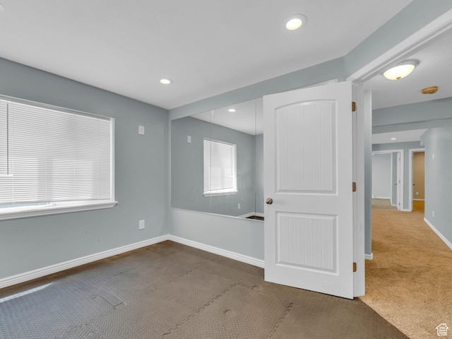 empty room with carpet floors, recessed lighting, and baseboards