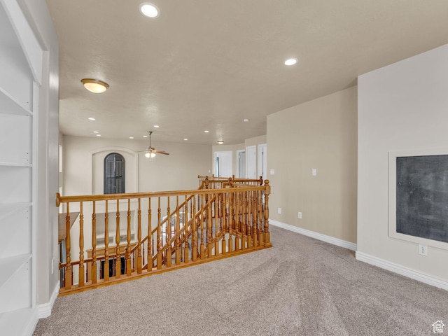 hall with an upstairs landing, carpet floors, recessed lighting, and baseboards