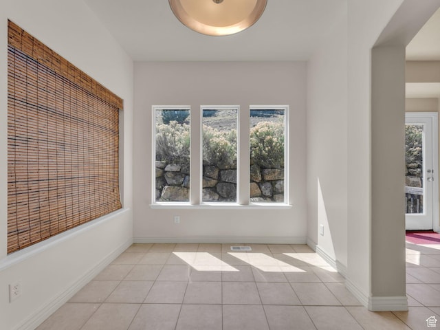 spare room with light tile patterned floors and baseboards