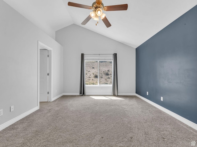 carpeted spare room with a ceiling fan, vaulted ceiling, and baseboards