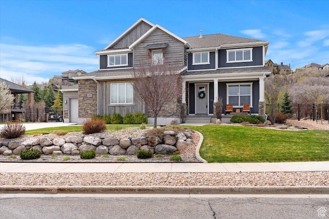 view of front of house with covered porch, stone siding, and a garage