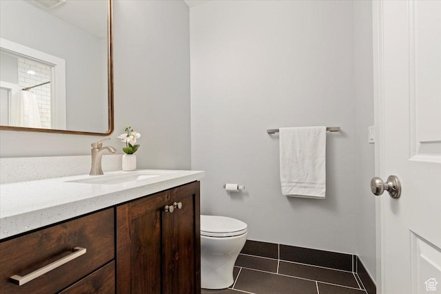 bathroom featuring vanity, tile patterned flooring, and toilet