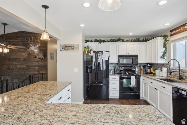 kitchen featuring backsplash, a sink, black appliances, dark wood-style floors, and white cabinetry