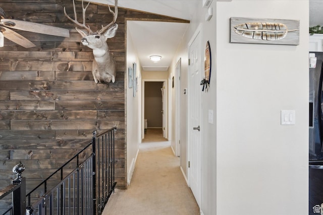 hall featuring light colored carpet and baseboards