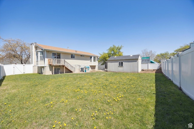 view of yard featuring a fenced backyard, an outbuilding, and a gate
