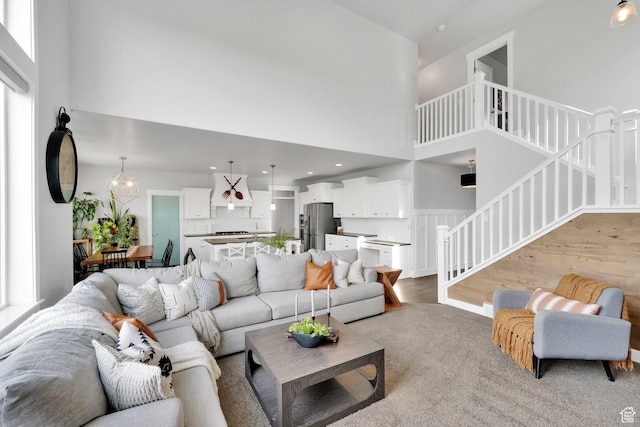 2385 E 430 S, Spanish Fork, UT 84660 - living area featuring light wood-type flooring, a towering ceiling, a wealth of natural light, and stairs