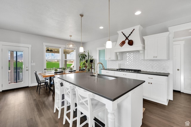2385 E 430 S, Spanish Fork, UT 84660 - kitchen with dark countertops, a sink, stainless steel gas cooktop, a kitchen island with sink, and tasteful backsplash