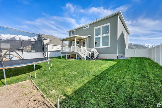 2385 E 430 S, Spanish Fork, UT 84660 - back of house featuring a yard, a trampoline, a fenced backyard, and stucco siding