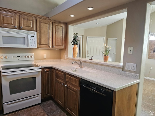 kitchen featuring a sink, white appliances, light countertops, dark tile patterned floors, and recessed lighting