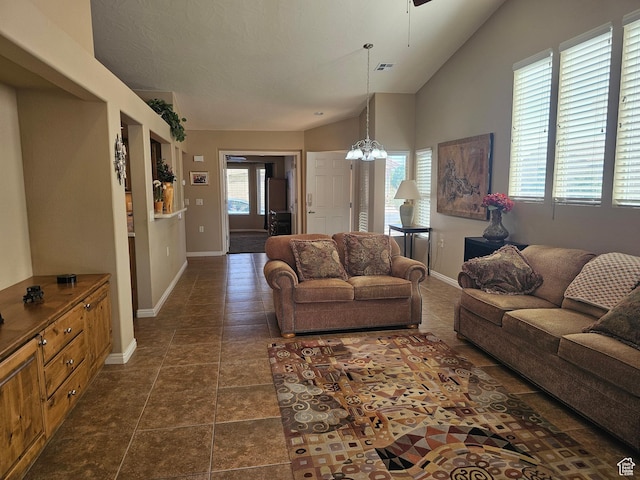 living room with visible vents, vaulted ceiling, baseboards, and a ceiling fan
