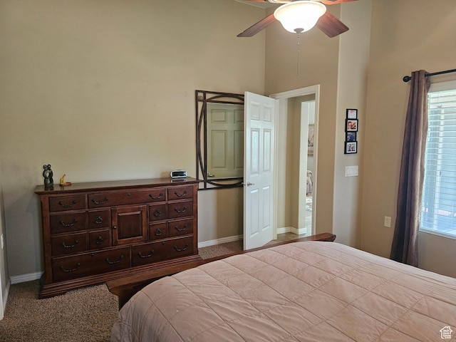 carpeted bedroom with ceiling fan, baseboards, and multiple windows