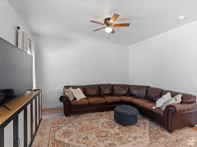 living room featuring wood finished floors, a ceiling fan, and baseboards