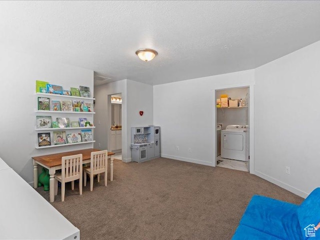 rec room with carpet floors, baseboards, washer and dryer, and a textured ceiling
