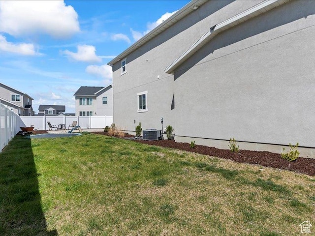 exterior space featuring a fenced backyard, a yard, central AC, and stucco siding