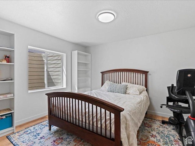 bedroom with baseboards and wood finished floors