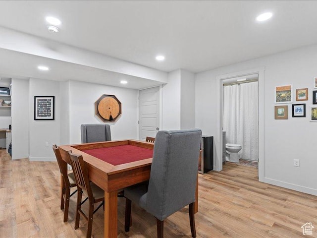 dining area featuring light wood finished floors, baseboards, and recessed lighting