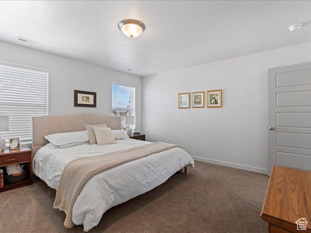 carpeted bedroom featuring baseboards and visible vents
