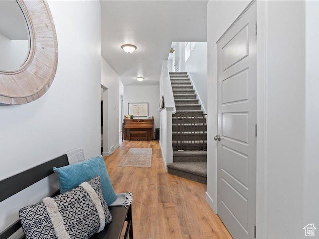 corridor with stairs and light wood-style floors