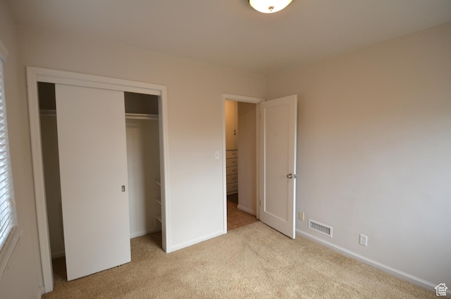 unfurnished bedroom featuring baseboards, carpet floors, visible vents, and a closet