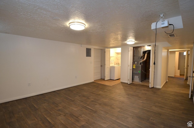 unfurnished living room featuring wood finished floors, a textured ceiling, and washer / clothes dryer