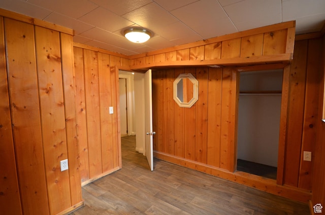 unfurnished bedroom with wood walls and wood finished floors