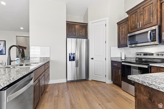 315 W Camino Borde, Washington, UT 84780 - kitchen with dark brown cabinetry, light stone countertops, a sink, and appliances with stainless steel finishes